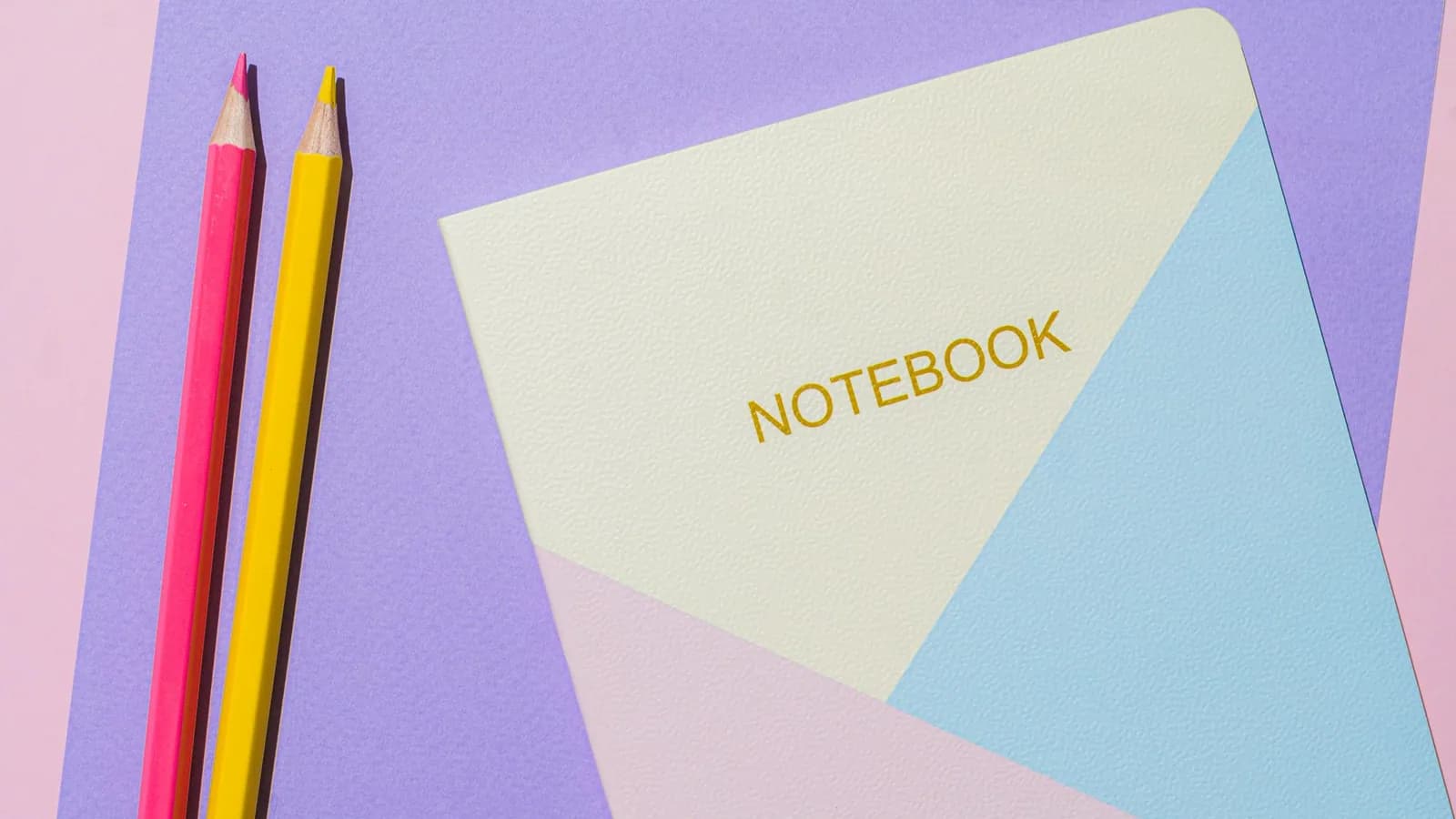 Pastel notebooks and pencils laid out for school.