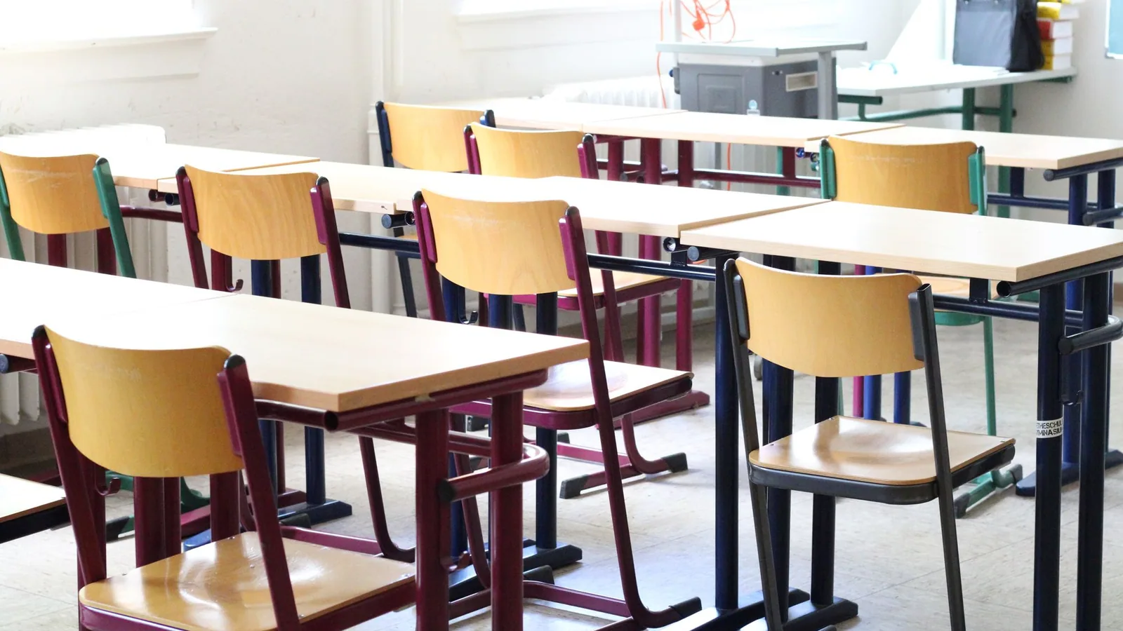 Rows of desks and chairs in a bright, empty classroom.