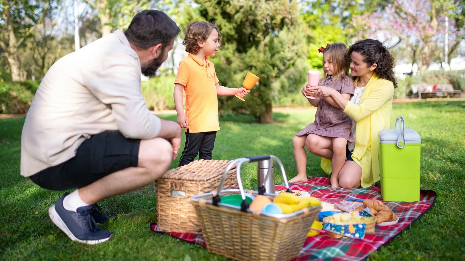 A family enjoying a picnic together in a green park.