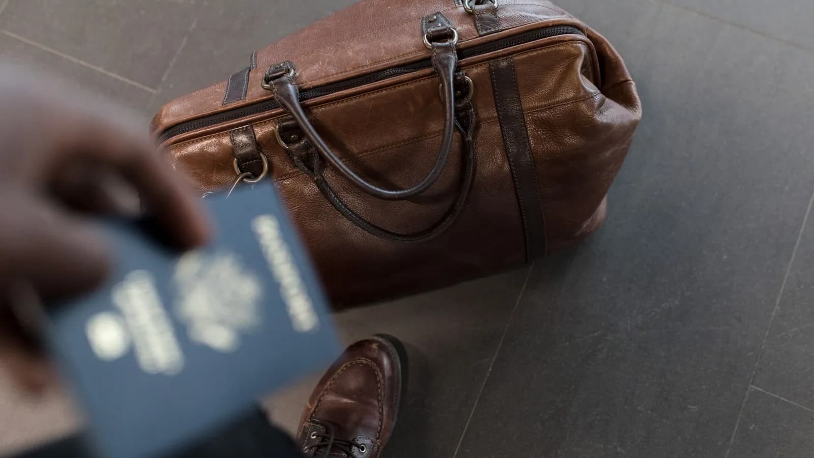 A leather travel bag and passport ready for a trip.